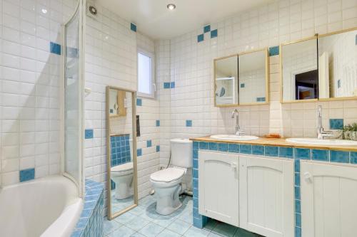 une salle de bain avec une baignoire, des toilettes et un lavabo dans l'établissement Large Duplex Flat in a Courtyard - Trendy Paris 10, à Paris