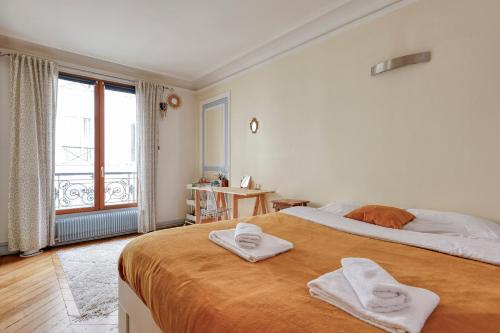 une chambre avec un grand lit avec des serviettes dessus dans l'établissement Large Duplex Flat in a Courtyard - Trendy Paris 10, à Paris