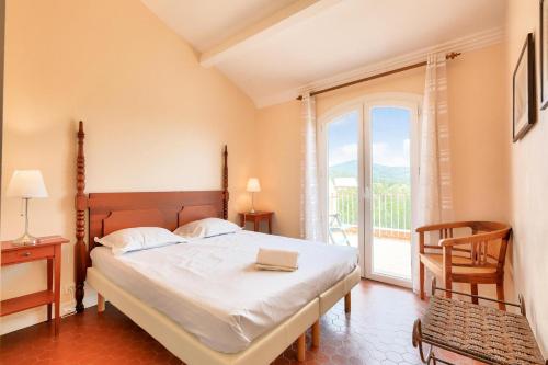 une chambre avec un lit et une grande fenêtre dans l'établissement Les Villas aux Restanques du Golfe de St Tropez - maeva Home - Villa vue colline 3 pièces 6 personnes - Prestige MAE-8591, à Grimaud