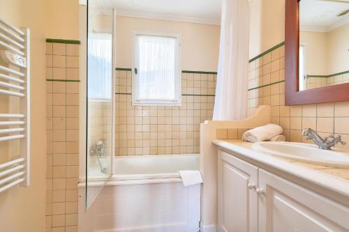 une salle de bain blanche avec un lavabo et une douche dans l'établissement Les Villas aux Restanques du Golfe de St Tropez - maeva Home - Villa vue colline 3 pièces 6 personnes - Prestige MAE-8591, à Grimaud