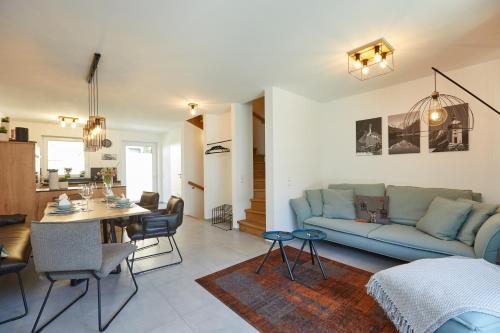 a living room with a blue couch and a table at 3KORNHAUS - Das neue Alpendomizil in Garmisch-Partenkirchen
