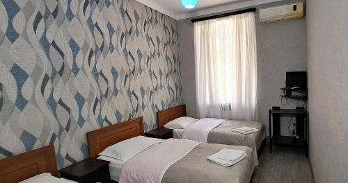 a hotel room with two beds and a wall at Sighnaghi Central in Sighnaghi