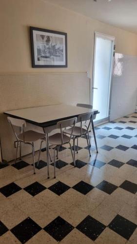 - une table et des chaises dans une chambre avec un sol en damier dans l'établissement Appartement familial région PACA, au Muy
