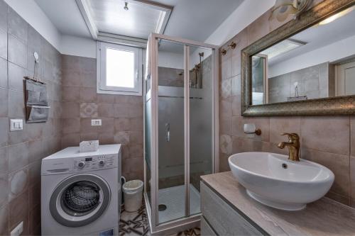 a bathroom with a sink and a washing machine at Borgo Diaz in Cisternino