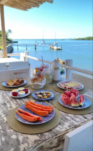 a table with plates of food on top of the water at Restaurante & Pousada Gaivota in Santo André