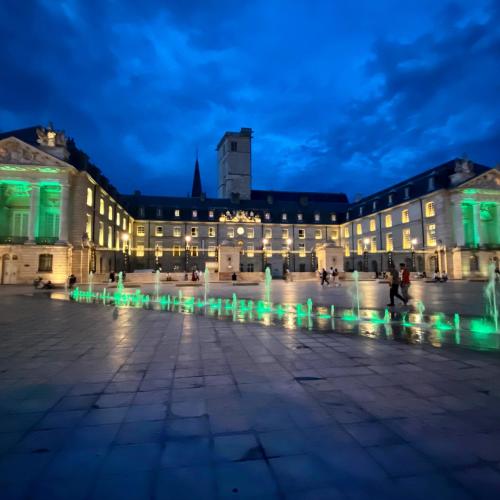 a building with a fountain in front of it at night at LOFT & SPA PRIVATIF in Dijon