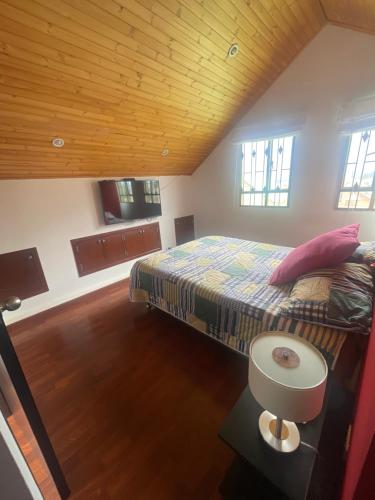 a bedroom with a bed and a wooden ceiling at Vinculado a las montañas y a la naturaleza in Guasca