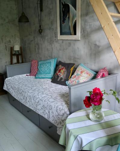 a bedroom with a bed with a vase of flowers on a table at Oak House Nowy Dworek in Świebodzin
