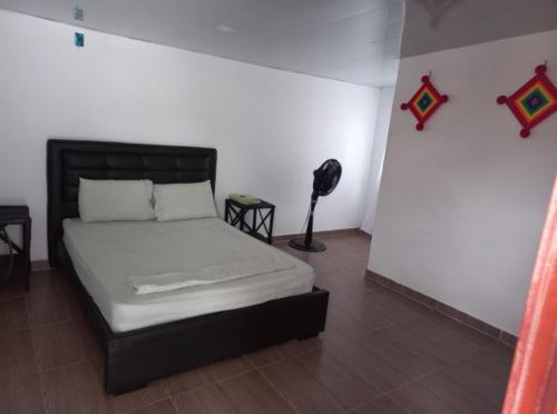 Un dormitorio con una cama y una lámpara. en PLAYA ARCO IRIS, en Cabo de la Vela