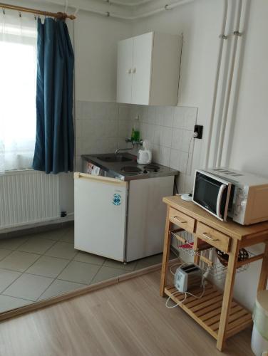 a kitchen with a white refrigerator and a microwave at Paprika vendégház in Harkány