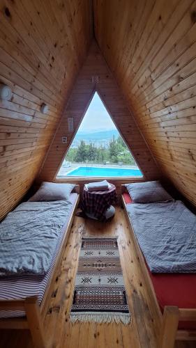 a attic room with two beds and a window at Bungalovi Lana in Sarajevo