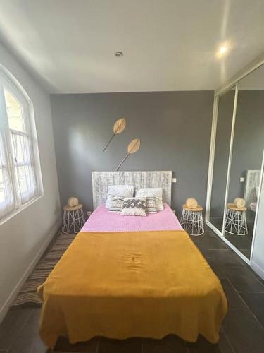 une chambre avec un grand lit avec une couverture jaune dans l'établissement Le forum n2 Arles Centre, à Arles