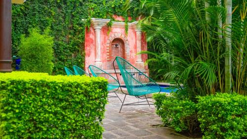 a group of chairs sitting in a garden at Casa Mia Hotel in Antigua Guatemala