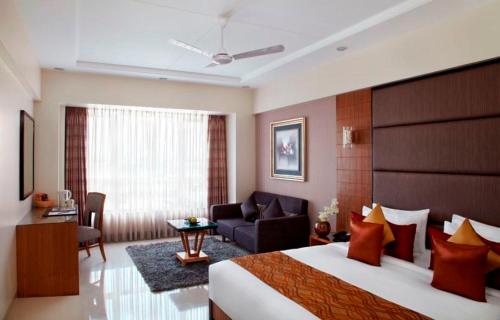 a bedroom with a large bed and a living room at The Radiant Swan in Dahej
