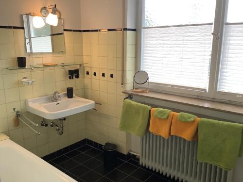a bathroom with a sink and green and orange towels at Ferienwohnung Kliniknähe mit Blick ins Grüne in Tübingen