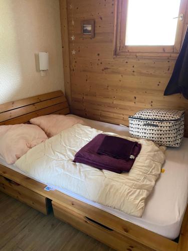 - un lit avec ordinateur portable dans la chambre dans l'établissement Appartement rez de jardin au pied des pistes, à Les Allues