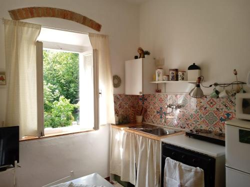 cocina con fregadero y ventana en Soluna en Maresca