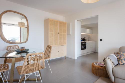 un salon avec une table et un canapé dans l'établissement GOODLIFEPRAMOUSQUIER classe 3 etoiles Appartement 2 ch, belle vue mer et nature, calme et plage à pied, au Lavandou