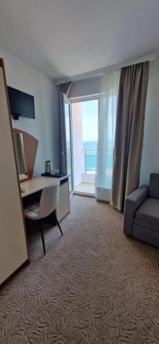 a room with a desk and a couch and a window at Elite Family Hotel in Kiten