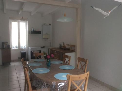 une cuisine avec une table avec des chaises et une salle à manger dans l'établissement Vacances mer au CROISIC, au Croisic