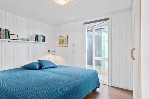a bedroom with a blue bed and a window at Panorama udsigt in Kolding