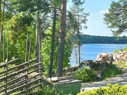 a wooden bench next to a path next to a lake at 4 person holiday home in HERRäNG-By Traum in Herräng