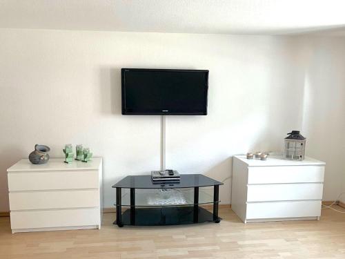 a living room with a tv on the wall and a table at Forest Stay in Elbingerode in Elbingerode