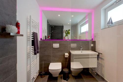 a bathroom with a toilet and a sink and a mirror at Ferienhaus am Yachthafen in Peenemuende in Peenemünde