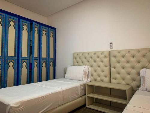 a bedroom with a large bed and blue windows at Dar Saida Hora in Chefchaouene