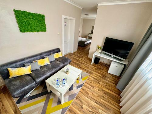 a living room with a couch and a tv at Hotel Amfora in St. St. Constantine and Helena