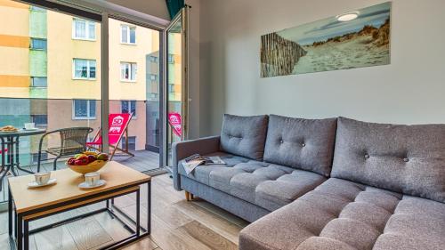 5D Apartamenty Fredry 2/47 في كولوبرزيغ: غرفة معيشة مع أريكة وطاولة