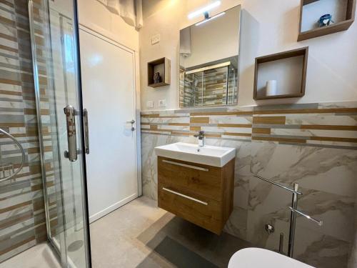 a bathroom with a sink and a shower and a mirror at Villino La Fresia in Castiglioncello