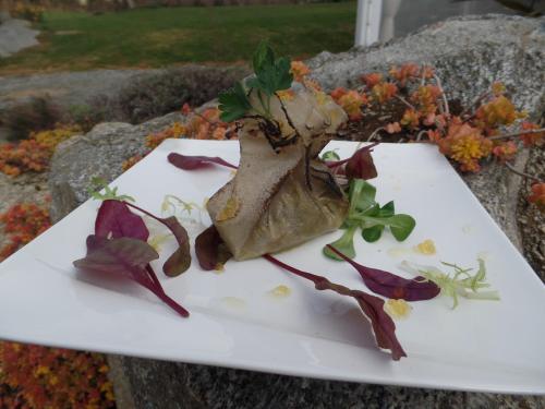 a white plate with a dish with flowers on it at Logis Le Commerce in Guichen