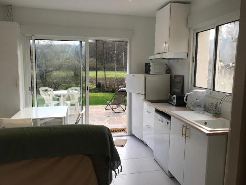 Il comprend une cuisine avec des placards blancs et offre une vue sur une terrasse. dans l'établissement coeurdevallee, à Châteaufort