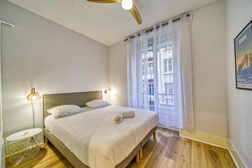 une chambre avec un grand lit et une grande fenêtre dans l'établissement La Grande Suite Championnet - Calme & Confort, à Grenoble