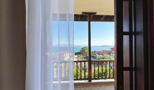 a room with a window with a view of the ocean at Viva Properties in Ouranoupoli