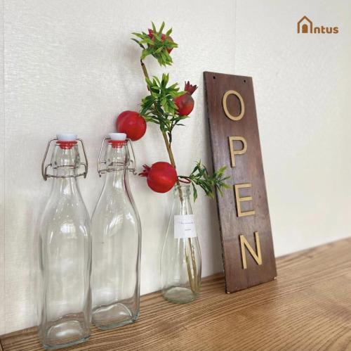 three bottles sitting on a table with tomatoes in them at Antus Homestay in Quang Ninh