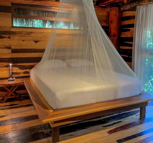 a bed with a net on top of it at Treehouse Tulum H2Ojos in Tulum