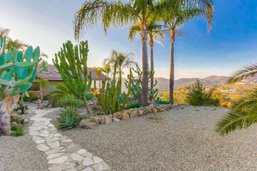 a garden with palm trees and a house at Gorgeous Private Estate with Pool & Pickleball Court in Lakeside