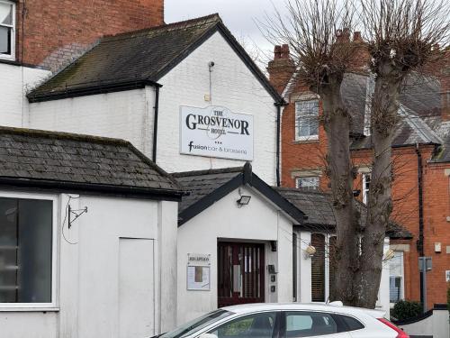 a car parked in front of a white building at Grosvenor Hotel Rugby in Rugby