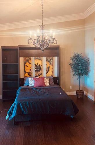 a bedroom with a large bed with a chandelier at Gorgeous Private Estate with Pool & Pickleball Court in Lakeside