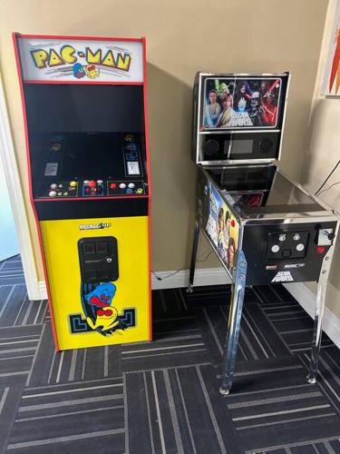 a yellow pinball machine next to a video game at Gorgeous Private Estate with Pool & Pickleball Court in Lakeside