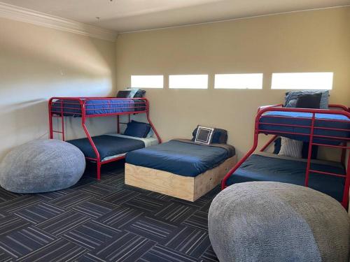 a room with three bunk beds and two ottomans at Gorgeous Private Estate with Pool & Pickleball Court in Lakeside