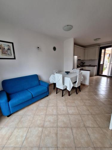 a living room with a blue couch and a table at [2 KM DAL MARE] Villetta relax con barbecue in Palmadula