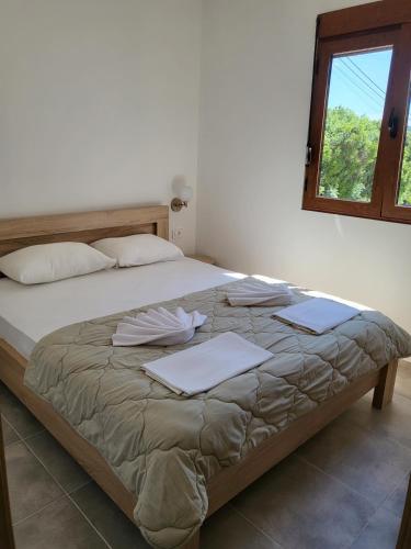 a bedroom with a large bed with pillows and a window at Bungalovi Arabela in Utjeha