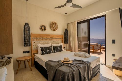 Un dormitorio con una cama y una ventana grande. en ArtOikia Luxury Villas, By Hellocrete, en Saktoúria