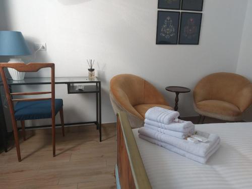 a room with a bed and two chairs and a desk at B&B Il Borgo delle Emozioni in Dolianova
