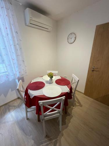 a dining room with a red and white table and chairs at Apartma Kiki in Koper