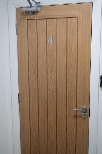 a wooden door with the number four on it at Digbeth Aparthotel in Birmingham