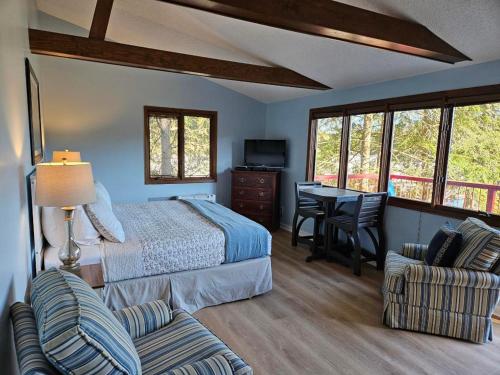 a bedroom with a bed and a desk and chairs at Boundary Waters Resort & Marina in Hiawassee